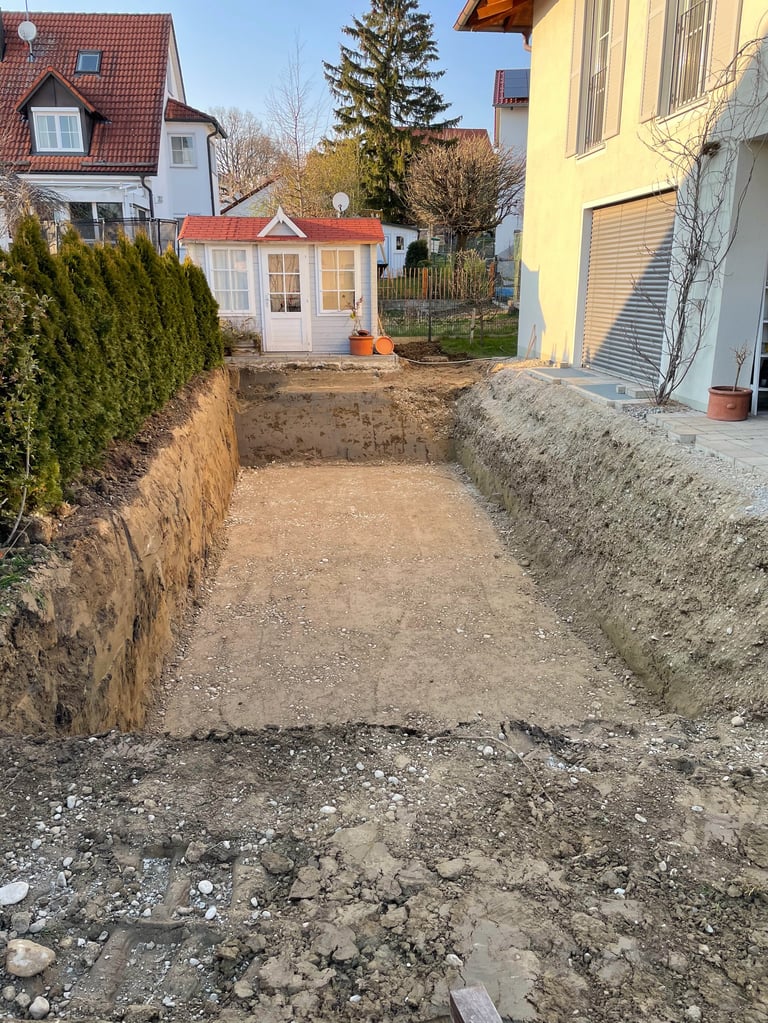 Excavated pathway between houses with dirt trenches